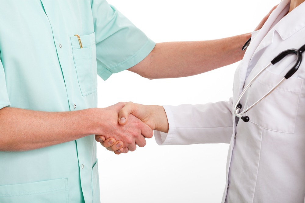 Doctors are shaking hands to say thank you for good teamwork
